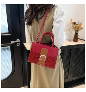 Detail shot of a dark red contrast handbag showing D-shaped buckle and crocodile pattern