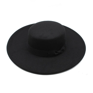 Detail of a vintage flat top wool hat with wide brim and black silk ribbon bow