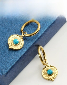 Close-up of 18K gold-plated drop earrings with round turquoise and sunray texture