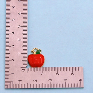 Detail view of 1.5cm red apple charm with scale showing size for jewelry making