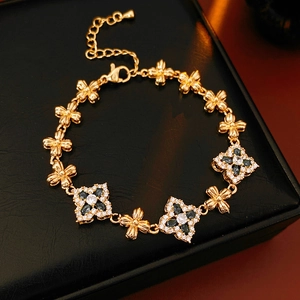 Detalle de pulsera vintage dorada con flores de circón azul en estuche de cuero