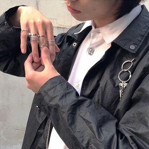 Street style silver ring set with minimalist geometric designs and a skull pin brooch