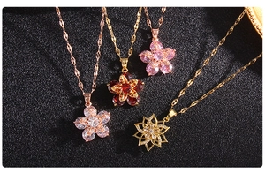 Detailed view of four assorted gold clover pendants with zircon and gemstone inlays