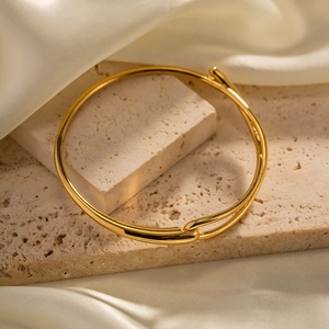 Bracelet jonc ouvert en acier inoxydable plaqué or 18K sur un support en pierre naturelle