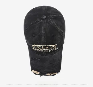 Close-up of vintage distressed denim cap featuring New York embroidery and frayed holes
