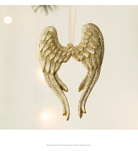 Détail de l'ornement aile d'ange or champagne avec paillettes et ruban de suspension