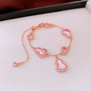 Detailed macro view of rose gold hulu charms with pink mother of pearl and zircon pavé
