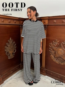 Dettaglio del set t-shirt a righe bianche e nere e pantaloni larghi alla moda