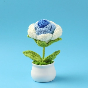 Handmade crochet rose in white and blue yarn with white ceramic pot on light blue background