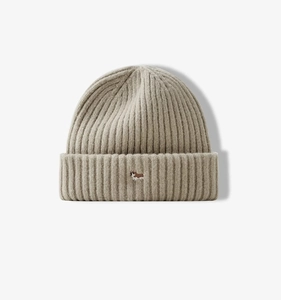Detailed view of oatmeal ribbed knit beanie with small corgi embroidery on the folded cuff