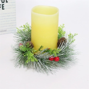 Detailansicht eines Weihnachtskerzenrings mit Tannennadeln, roten Beeren und Kerze