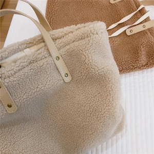 Detailed texture of beige and brown fleece tote bags with faux leather handles and rivets