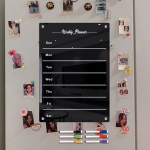 Macro detail of magnetic acrylic weekly planner with six colorful markers on refrigerator
