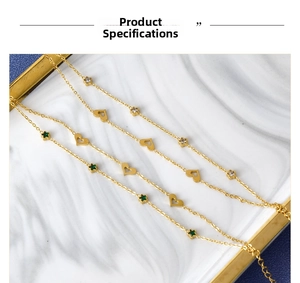 Detail of gold chain with hollow heart charms and starry zircon insets on marble