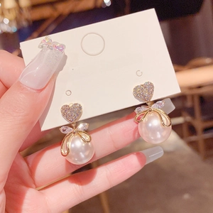 Elegante Perlenohrringe mit Herz-Kristall und Schleifendesign auf einer Displaykarte
