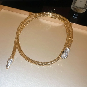 Macro shot of flexible gold mesh snake necklace with sparkling rhinestone head and tail