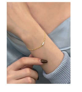 Detailed view of S925 sterling silver golden chain bracelet with two cubic zirconia stones