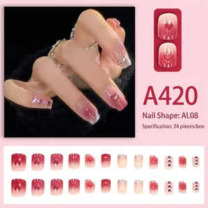 Press-on nails with pink blush gradient, heart patterns, and purple butterflies