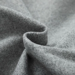Macro shot of gray wool fabric texture showing soft fibers and thickness for women's jacket