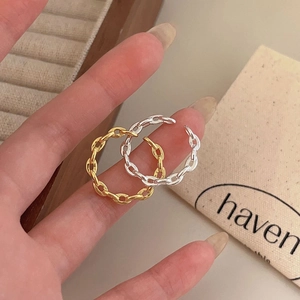 Close-up of gold and silver chain link rings featuring an adjustable open design