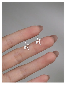 Macro shot of S925 silver north star stud earring with sparkling zircon held by fingers