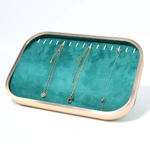 Detail view of emerald green velvet jewelry tray with gold metal frame for necklaces