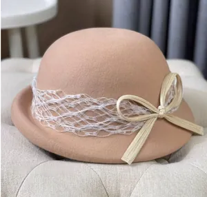 Detail of camel wool felt bucket hat with white mesh lace and ribbon bow decoration