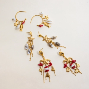 Dettaglio di orecchini bohémien in acciaio inossidabile oro 18K con conchiglie e stelle