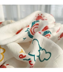 Detailed macro view of soft muslin bamboo cotton fabric with sun and rainbow print
