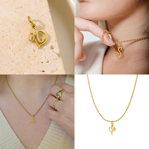 Detailed view of artistic golden hollow letter pendants on beaded chains with model styling