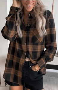 Detail of brown plaid shirt featuring classic buttoned collar and dual chest pockets