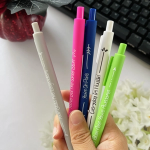 Close-up of five colorful retractable gel pens with inspirational quotes in hand