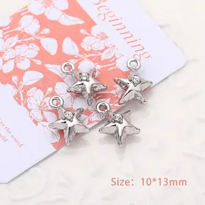 Detailed view of silver star alloy pendants with rhinestones measuring 10x13mm for DIY jewelry