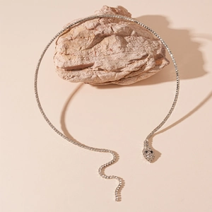 Vue détaillée du collier serpent en argent serti de zircons posé sur une roche