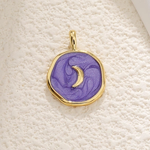 Detailed close-up of a gold celestial moon pendant with purple oil drip texture