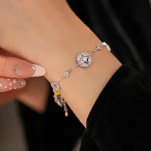 18K gold plated silver bracelet with zircon starburst charms on woman's wrist