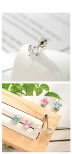 Macro shot of 5mm four-claw zircon earrings set in various pastel colors on wooden decor