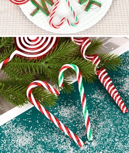 Detailed view of red, white, and green candy ornaments and canes on a Christmas scene