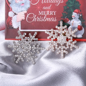 Gros plan de broches flocons de neige argent et or rose avec cristaux scintillants