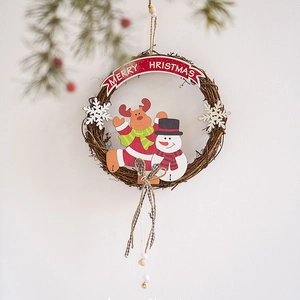 Christmas rattan wreath with snowman and reindeer figurines and Merry Christmas sign