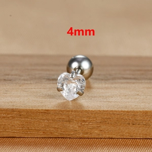 Macro detail of 4mm heart-shaped cubic zirconia stud earring on a natural wooden surface