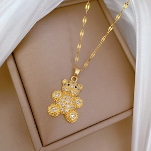 Close-up of a sparkling gold teddy bear pendant with crystals on a jewelry box