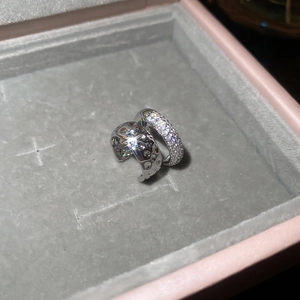 Détail de boucles d'oreilles argentées avec zircon et texture martelée dans un écrin