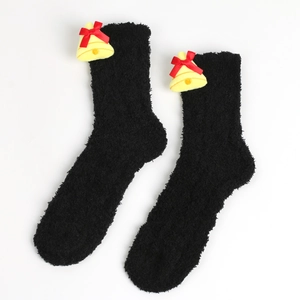 Detail von weichen schwarzen Korallenvlies-Socken mit gelben Glocken und roter Schleife