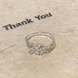 Macro detail of S925 sterling silver adjustable ring featuring delicate floral clusters