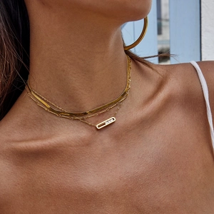 Close-up of layered gold stainless steel necklace with rhinestone geometric pendant