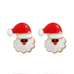 Gros plan de boucles d'oreilles Père Noël avec bonnet rouge sur fond blanc pur