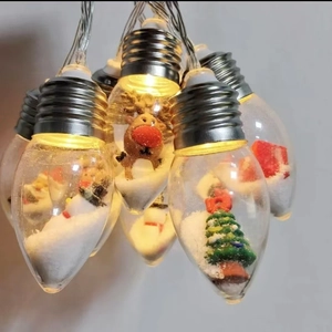 Close-up of LED Christmas light bulbs featuring miniature reindeer and snowman scenes