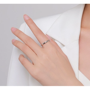Close-up of minimalist S925 sterling silver ring with a sparkling small gemstone on finger