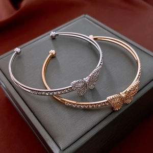 Detail of gold and silver open butterfly bracelets with sparkling cubic zirconia stones